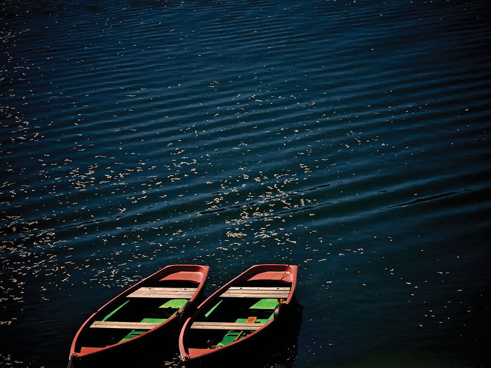 Two boats on dark blue water with ripples