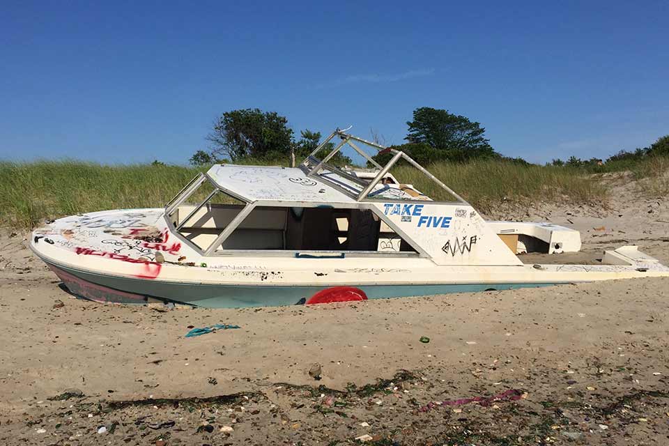 A photograph of a boat, grounded on a dry shore