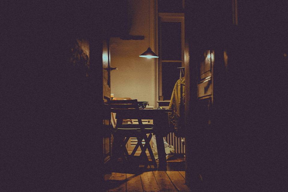 A photograph of a dimly lit nook in an apartment where a writing desk is set up