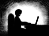 An illustration of a figure in shadow typing on a computer