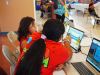 Two children study language materials on a computer