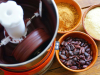 A photograph of a coffee grinder with beans and tumeric on the table