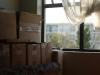 A photograph of a stack of boxes dimly lit by a window nearby