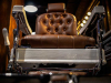 A photograph of a barber's chair as seen from the ground in front of it