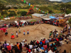 A bird's eye view of a small crowd watching dancers in bright clothing