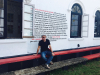 Sergio Chejfec sits in front of an art installation of his writing titled Dissemination of a Novel