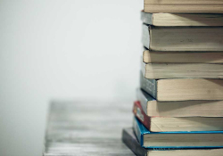 A photograph of a stack of books against a neutral white background